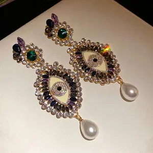Vintage evil eye earrings with colorful rhinestones and teardrop pearl charms.