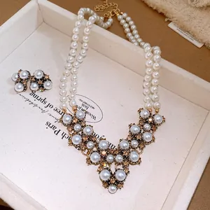 Vista dettagliata di un set di collana e orecchini di perle vintage su vassoio bianco