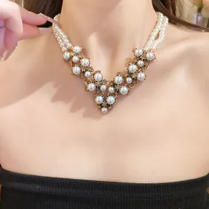 Dettaglio macro di una collana di perle vintage a doppio strato con pendente a V