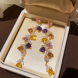 Close-up of heart-shaped multi-color cubic zirconia dangle earrings in a luxury box