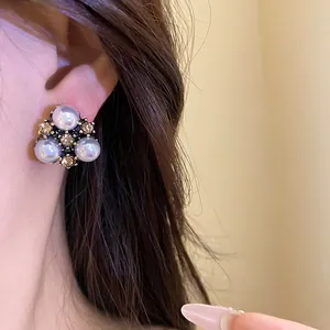 Dettaglio elegante di orecchini vintage con perle e strass indossati sul modello
