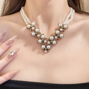 Dettaglio di una collana di perle vintage a doppio filo con un elegante ornamento a forma di V