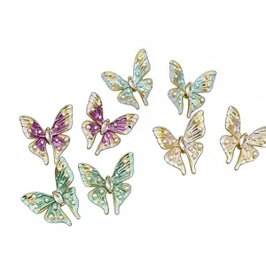 Elegant enamel butterfly earrings with pearls and rhinestones on white background