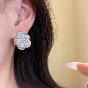 Primo piano di eleganti orecchini a lobo floreali con petali smaltati colorati e zircone