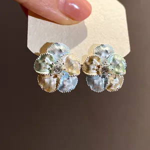 Dettaglio macro di orecchini a lobo a fiore multicolore con zircone trasparente
