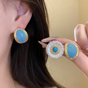 Detailed macro view of vintage oval turquoise stud earrings and floral zircon jewelry pieces