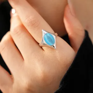 Elegant silver open ring featuring an oval blue cat-eye stone in a star-shaped frame