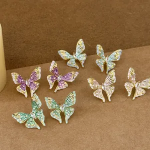 Detailed view of enamel butterfly stud earrings with pearl accents and marquise crystal.