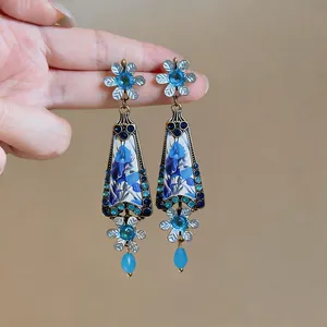 Detailed view of vintage blue flower drop earrings with intricate crystal accents.