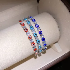 Close-up of three sparkling zircon bracelets with colorful evil eye charms in a box