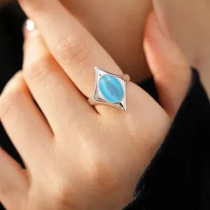 Elegant close-up of a star-shaped silver ring featuring a vibrant blue oval cat's eye stone.