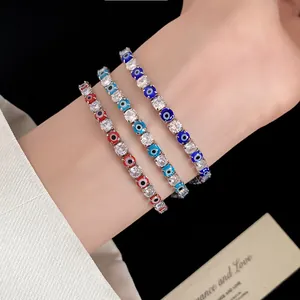 Detailed view of three dainty evil eye bracelets with cubic zirconia worn on a wrist