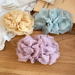 Primo piano di eleganti fermagli per capelli a fiore in rete in champagne, blu e viola.