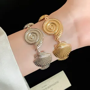 Detail of gold and silver seashell necklaces with polished crinkle texture