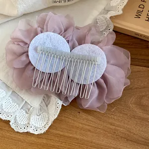 Dettaglio del retro di un pettine per capelli con fiori in rete rosa cipria per donna