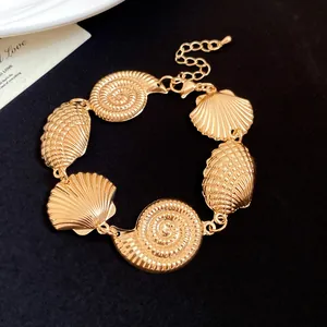 Detailed macro view of vintage gold metallic seashell bracelet with nautilus charms