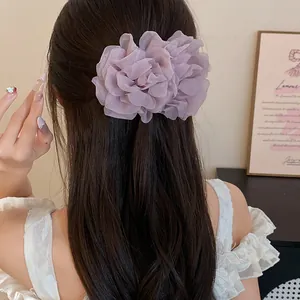 Dettaglio di un elegante fermaglio per capelli a fiore in rete viola su capelli