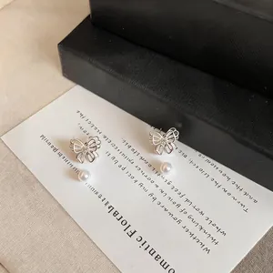 Close-up of elegant silver butterfly earrings with delicate pearls
