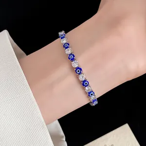 Detailed view of an Evil Eye tennis bracelet with sparkling zircons on a wrist.