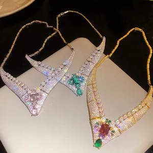 A detailed view of three vintage luxury V-shaped necklaces with sparkling colorful gemstones.