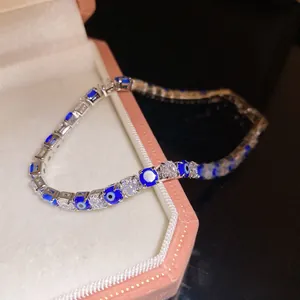 Detailed macro view of a luxury evil eye tennis bracelet with clear sparkling zircons on a box.