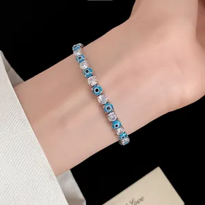Detailed close-up of a stylish evil eye zircon tennis bracelet on a model's wrist