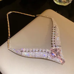 Exquisite close-up of a vintage V-shaped necklace with pink crystals and sparkling zircon stones