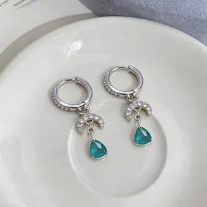 Elegant silver hoop earrings featuring crescent moon and green teardrop zircon charms