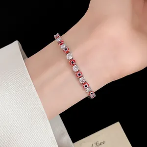 Macro detail of silver-tone bracelet with red evil eye beads and sparkling cubic zirconia