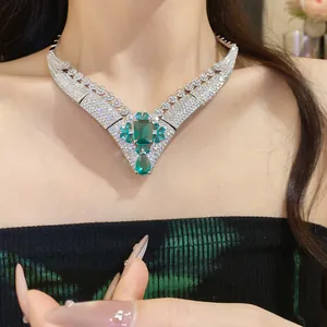 Macro view of the emerald green gemstone necklace with pavé-set shimmering clear stones.