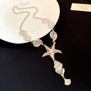 Close-up of vintage silver seashell and starfish necklace with pleated texture detail