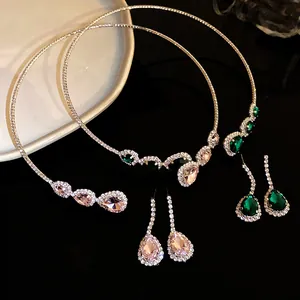 Vista dettagliata di set di collana e orecchini con strass a goccia in rosa e verde