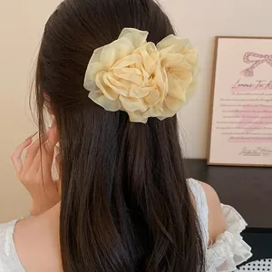 Vista dettagliata di un accessorio per capelli a fiore crema su lunghi capelli scuri