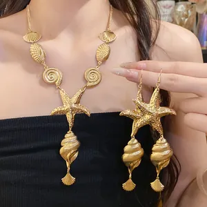 Close-up of vintage gold metallic sea snail and starfish necklace and earrings set
