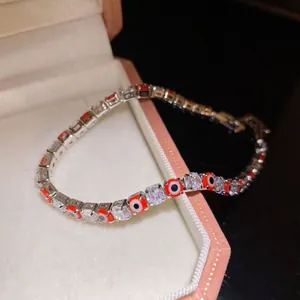 Detailed view of elegant silver bracelet with red evil eye beads and sparkling zirconia stones