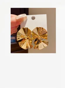 Statement gold ruffled circular stud earrings with high-shine metallic finish