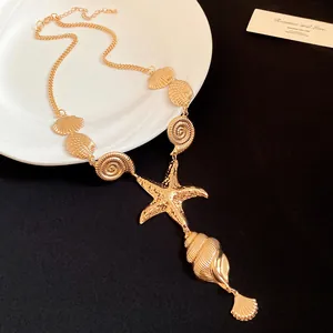 Detailed view of a gold-toned necklace featuring starfish and seashell pendants