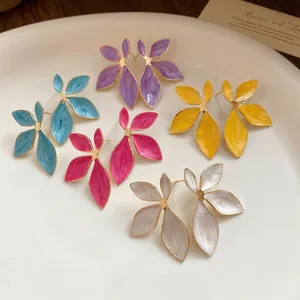 Vintage enamel flower stud earrings in multiple colors on a white ceramic plate