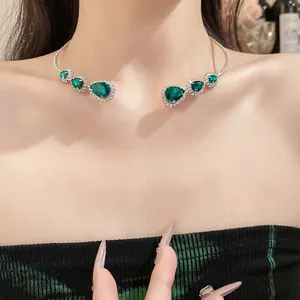 Primo piano di un girocollo di lusso con strass a goccia verde smeraldo sul collo