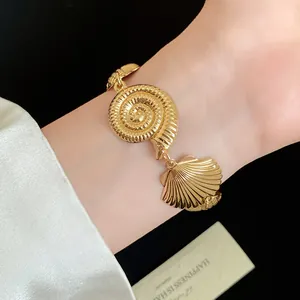 Detailed view of a gold metallic seashell bracelet featuring nautilus and clam shell designs
