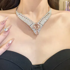 Close-up detail of a vintage 18k gold plated V-shaped necklace with pink gemstone