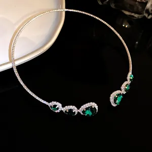 Dettaglio delle eleganti pietre preziose verdi a goccia sul girocollo color argento