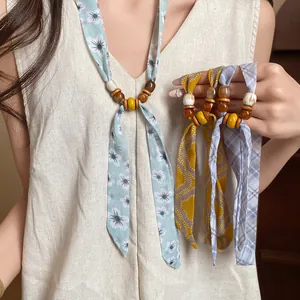 Close-up of floral and plaid beaded ribbon necklaces for spring fashion accessories.