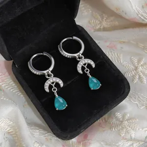 Elegant zircon moon and teal teardrop pendant hoop earrings in a black velvet box.