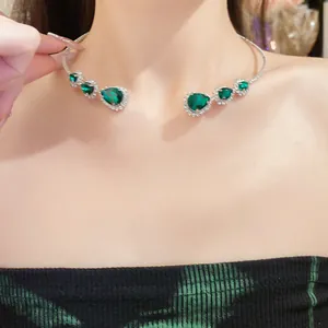 Vista dettagliata di una collana choker di lusso a goccia verde smeraldo con strass lucidi.