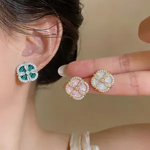 Gros plan de boucles d'oreilles fleur en zircon, finitions nacrées vert, rose, blanc.