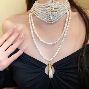 Vista dettagliata di un'elegante collana choker di perle a più strati con ciondolo a goccia.