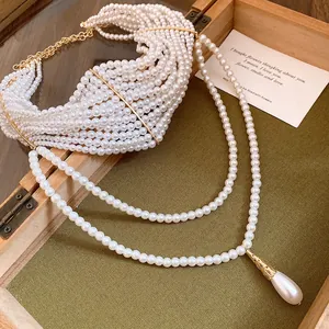 Dettaglio collana di perle multistrato con ciondolo a goccia d'acqua vintage oro