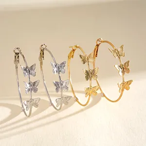 Close-up of elegant butterfly hoop earrings in silver and gold metallic finish