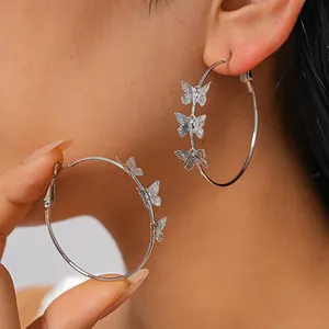 Elegant silver-plated butterfly hoop earrings displayed on a model's ear detail view